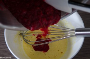 Johannisbeerpüree zur Eigelbmischung geben.