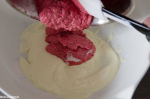 Abgebundenes Johannisbeerpüree zur aufgelösten Kuvertüre geben.