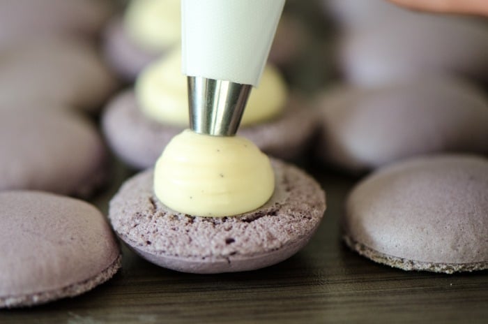 Die Füllung wird in die Macarons gespritzt.