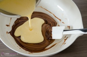 Milchcreme über Nougat und Kuvertuere gießen.