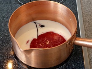 Milch,Himbeermark und Vanilleschote im Topf.