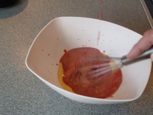 Die aufgekochte Himbeer- Milchmischung wird zu der Eigelbmasse gegeben.